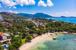 Beautiful aerial view of beach and sea with many tree and white cloud on blue sky in koh samui island for vacation and travel