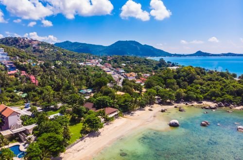 Beautiful aerial view of beach and sea with many tree and white cloud on blue sky in koh samui island for vacation and travel